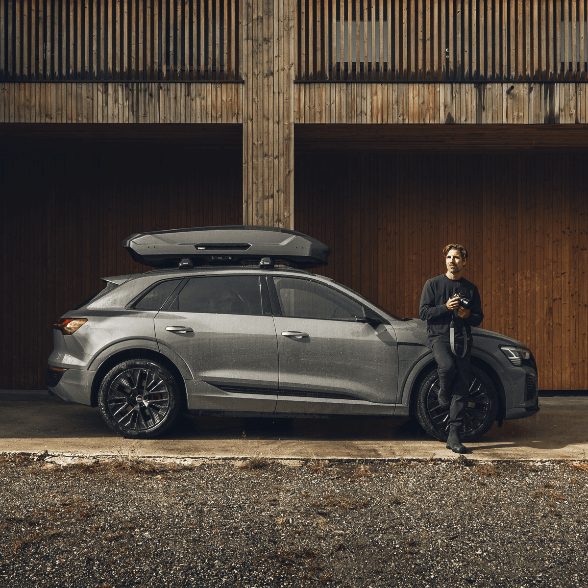 Thule Motion 3 mounted on a crossover beside a timber building
